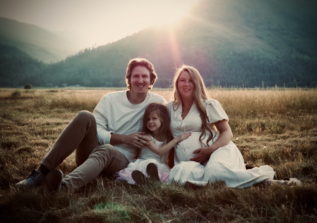 Family portrait in a golden meadow at sunset